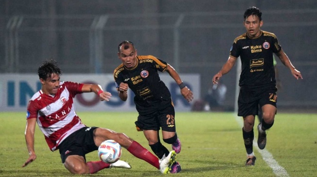 Winger Persija Jakarta, Riko Simanjuntak (tengah) berebut bola dengan pemain Madura United dalam laga pekan ke-8 BRI Liga 1 2023-2024 di Stadion Gelora Bangkalan, Madura, Minggu (13/8/2023) malam WIB. [Persija.id]